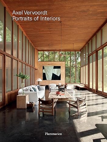A book cover titled Axel Vervoordt: Portraits of Interiors shows a spacious room with large windows, wooden ceiling, polished floor, modern furniture, and abstract art on the wall—a perfect addition to any Architect Gifts list. Published by Flammarion.