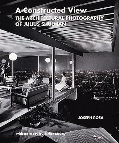 Black-and-white book cover titled A Constructed View: The Architectural Photography of Julius Shulman by Joseph Rosa. A perfect pick for Architect Gifts, it features a modern living room with large windows overlooking a city at night.